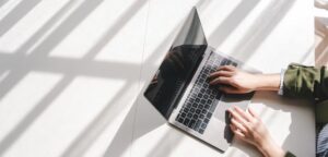 Kuva, jossa joku kirjoittaa läppärillä