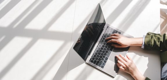 Kuva, jossa joku kirjoittaa läppärillä